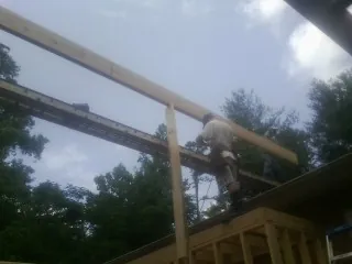 Carpenter setting a ridge beam over a new addition frame — Ice Dam Removal by Roofing Brothers in Mooreton